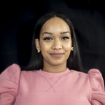 Christine Rondon Smiling in a Pink Shirt